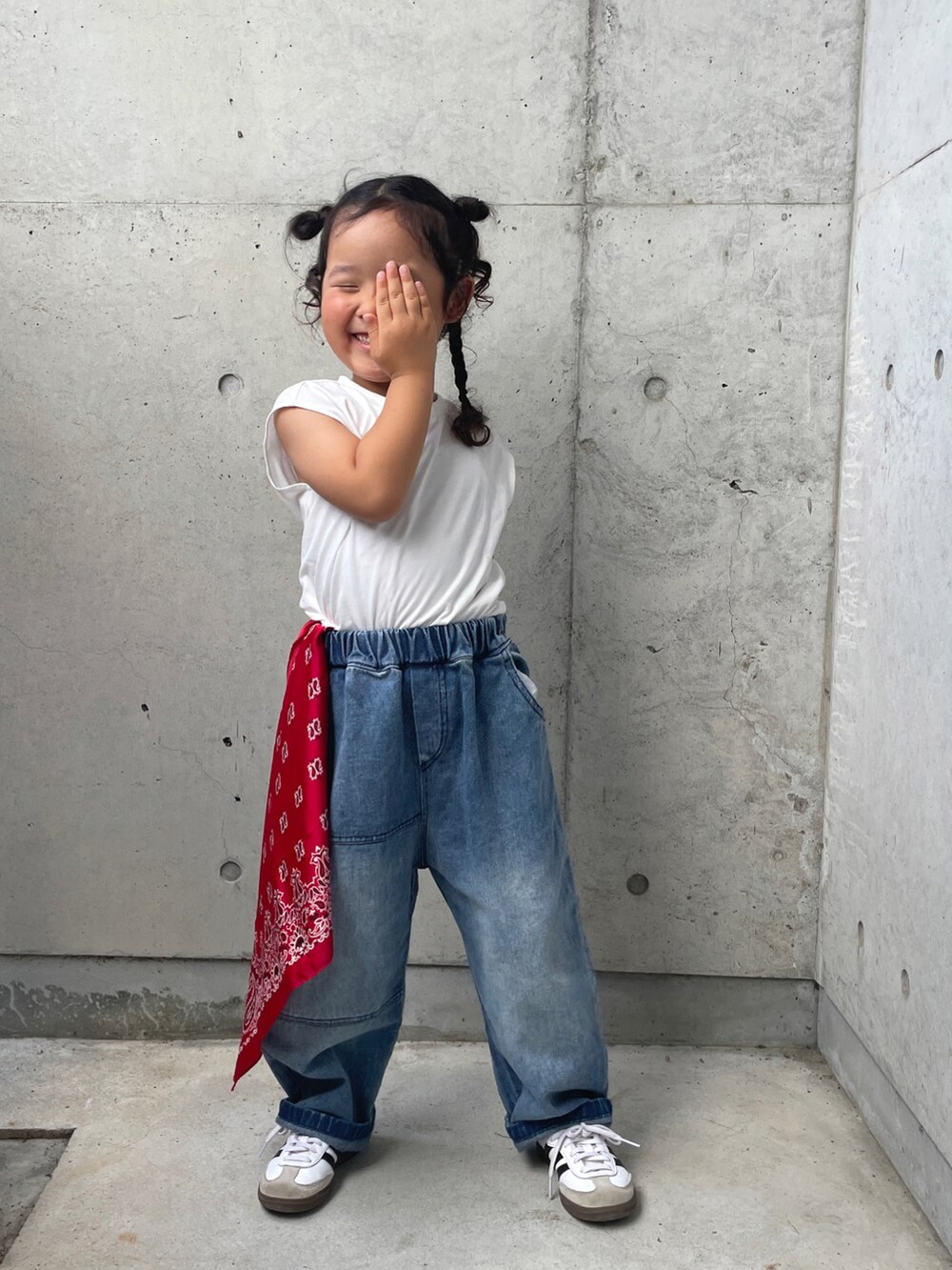 ブラック系のワンピース、ブルー系のデニムパンツ、ホワイト系のスニーカーを着用したキッズの夏コーディネートの2枚目の写真