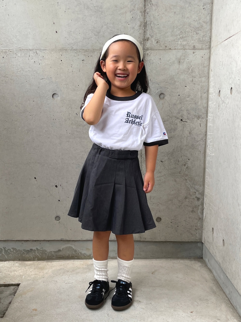 グレー系のスカート、ホワイト系のTシャツ/カットソー、ブラック系のスニーカーを着用したキッズの夏コーディネートの2枚目の写真