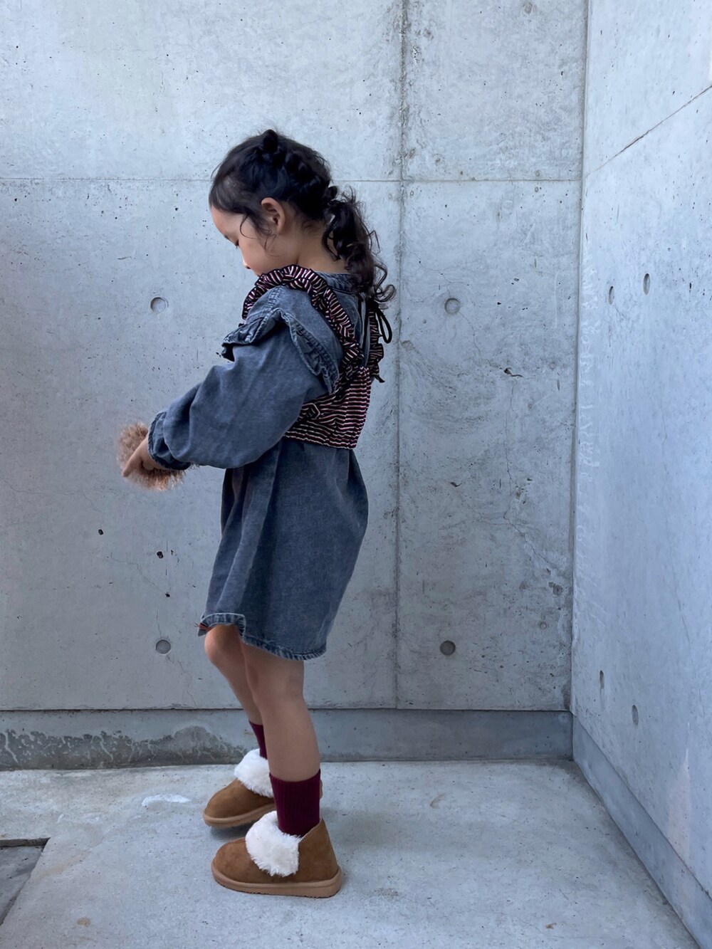 ブラウン系のショルダーバッグ、レッド系のキャミソール、ブラウン系のブーツを着用したキッズの秋コーディネートの5枚目の写真