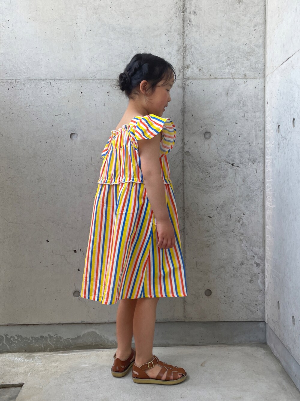 ベージュ系のサンダル、イエロー系のワンピースを着用したキッズの春コーディネートの5枚目の写真