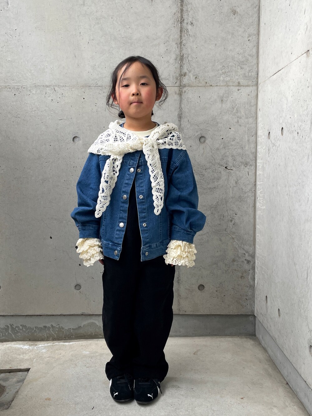 ブルー系のデニムジャケット、ブラック系のサロペット/オーバーオール、ブラック系のスニーカーを着用したキッズの春コーディネートの2枚目の写真