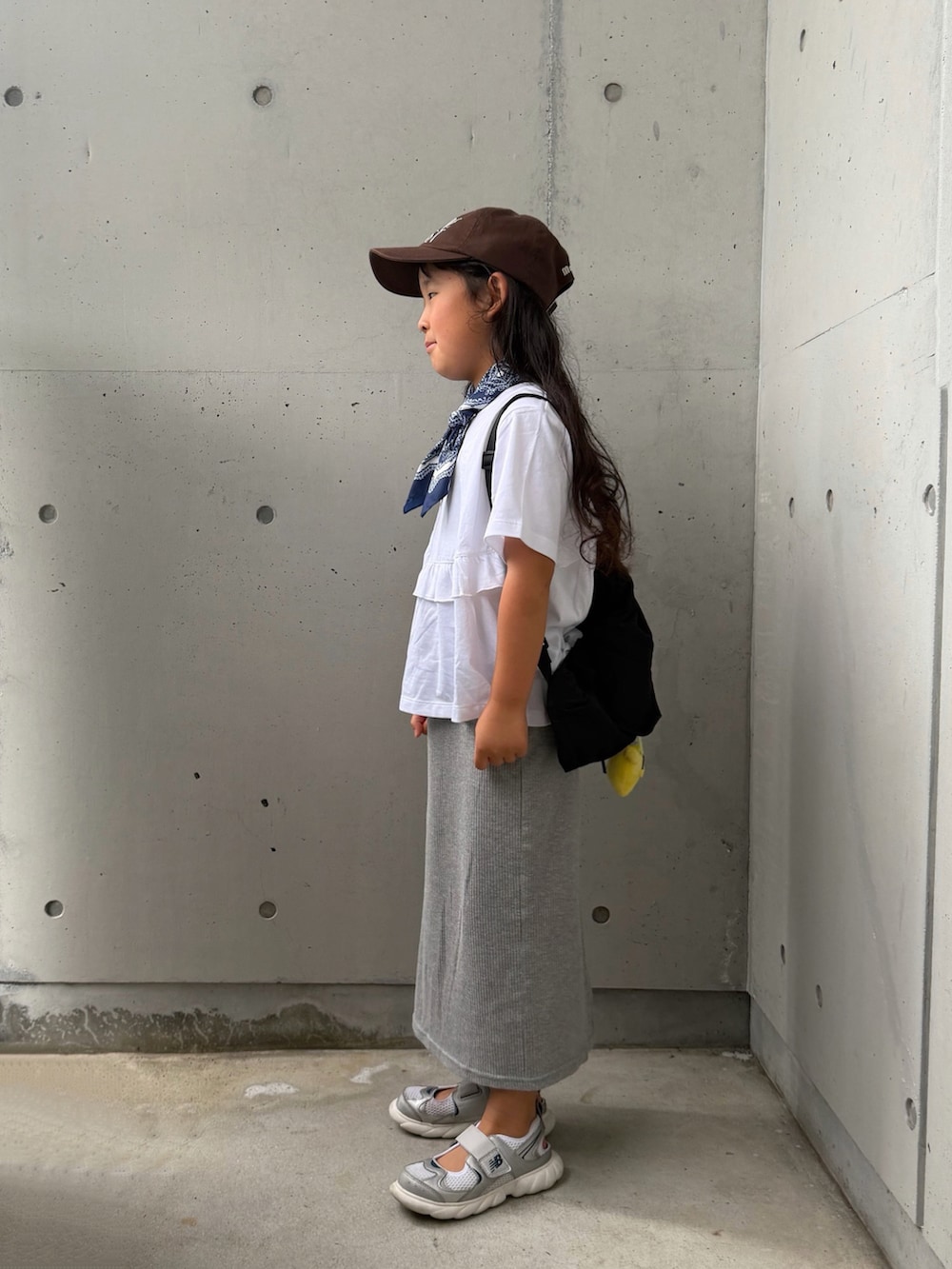 グレー系のスカート、シルバー系のスニーカー、ホワイト系のTシャツ/カットソーを着用したキッズの夏コーディネートの3枚目の写真