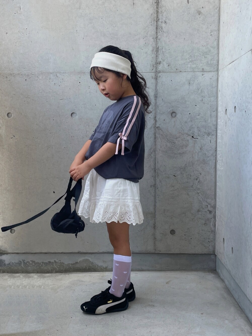 ブラック系のスニーカー、ブラック系のボディバッグ/ウエストポーチ、ブラック系のTシャツ/カットソーを着用したキッズの夏コーディネートの3枚目の写真