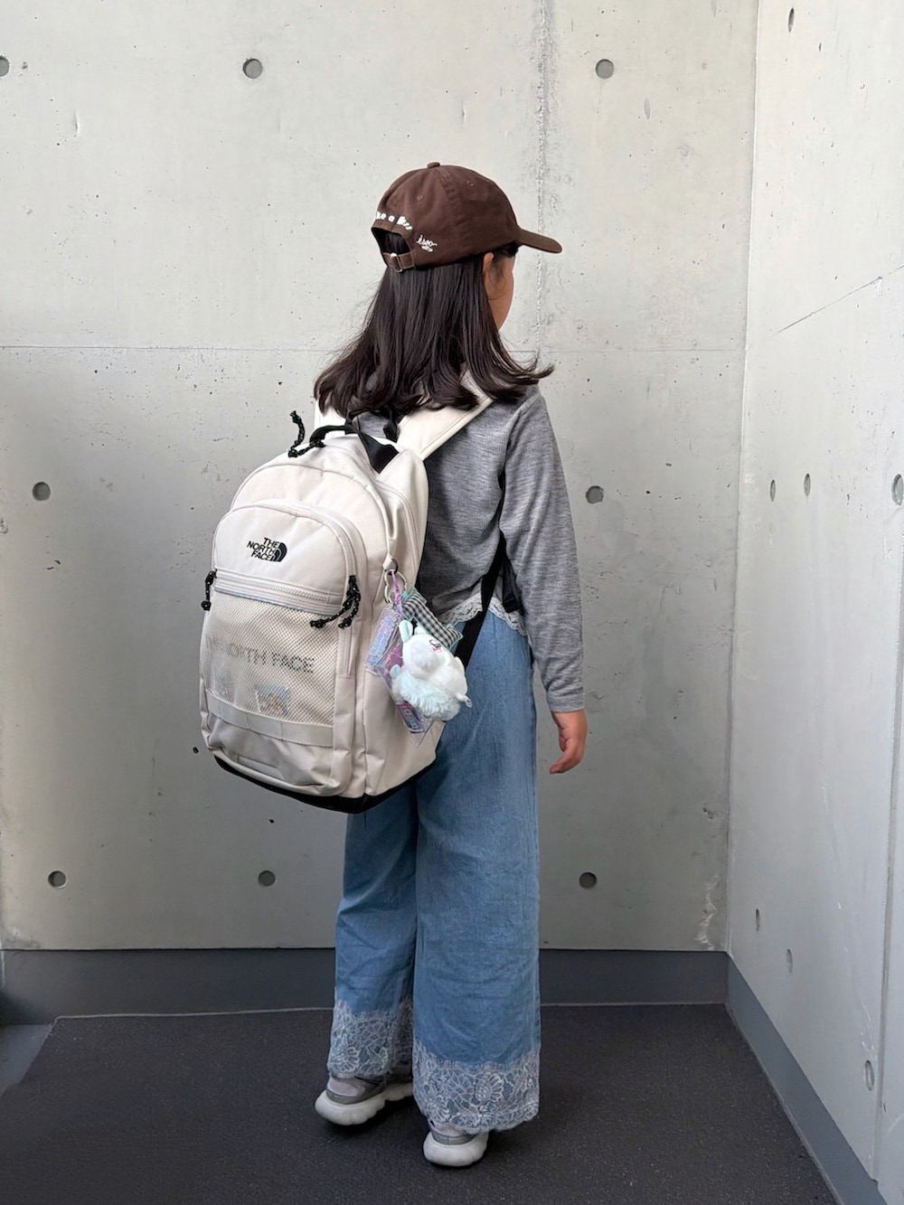 グレー系のTシャツ/カットソー、シルバー系のスニーカー、ブルー系のパンツを着用したキッズの秋コーディネートの2枚目の写真