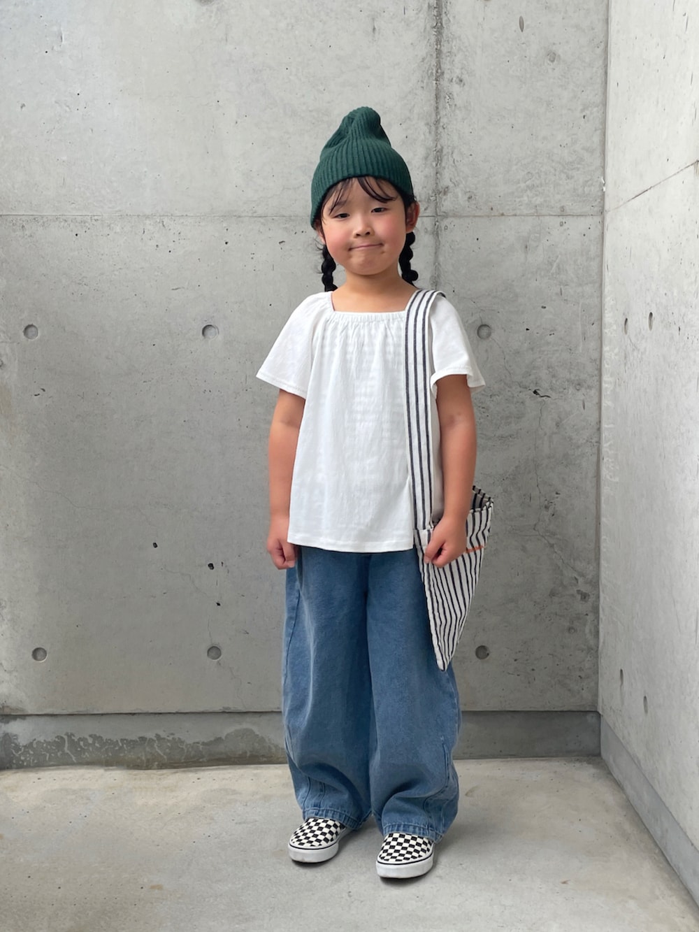 ホワイト系のキャミソール、ブラック系のスリッポン、ホワイト系のトップスを着用したキッズの秋コーディネートの5枚目の写真