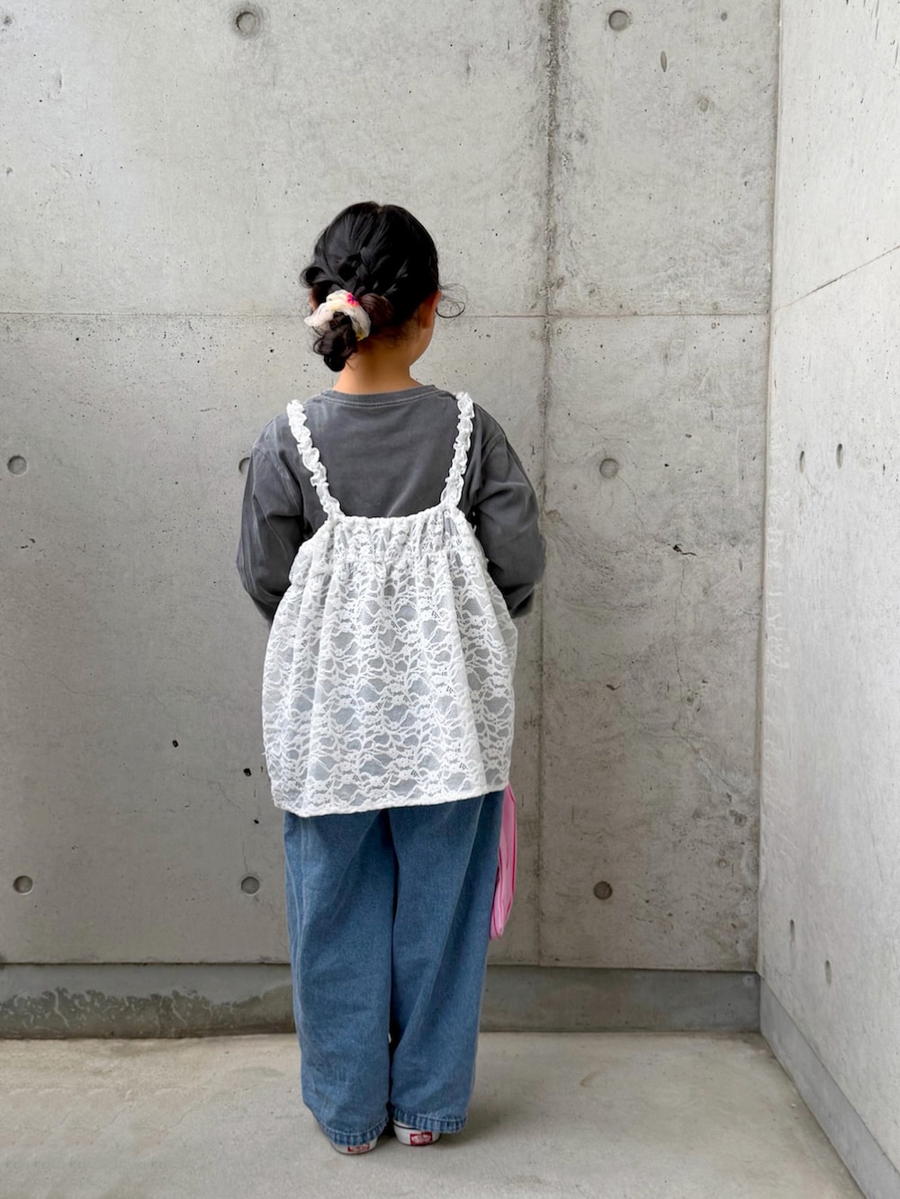 ピンク系のトートバッグ、ブラック系のスリッポン、ホワイト系のトップスを着用したキッズの春コーディネートの5枚目の写真