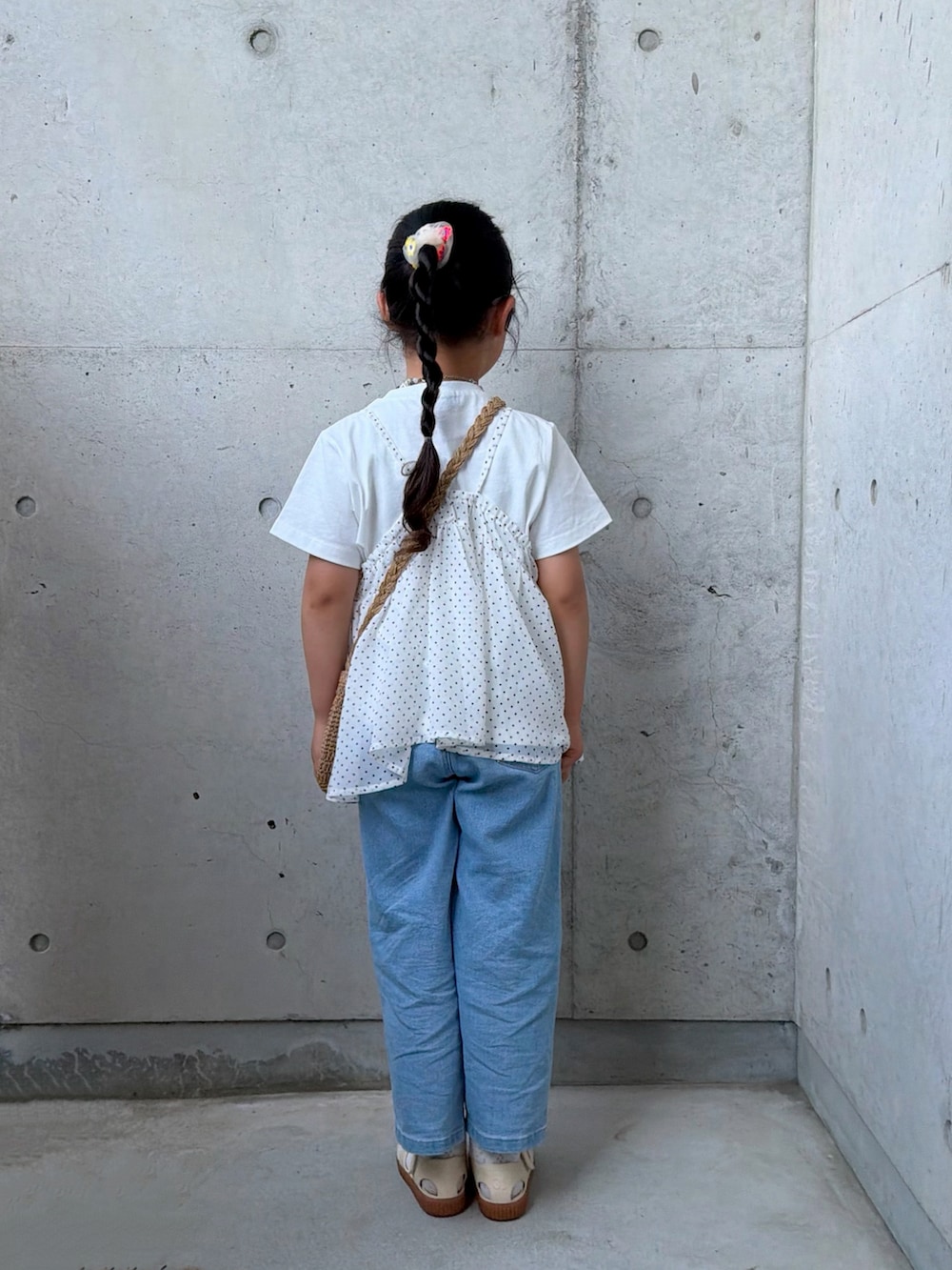 ブルー系のデニムパンツ、ホワイト系のTシャツ/カットソー、ベージュ系のショルダーバッグを着用したキッズの春コーディネートの3枚目の写真