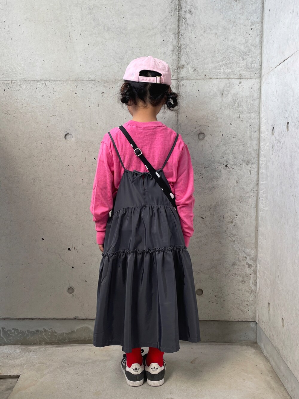 ピンク系のニット/セーター、グレー系のワンピース、ブラック系のショルダーバッグを着用したキッズの冬コーディネートの3枚目の写真