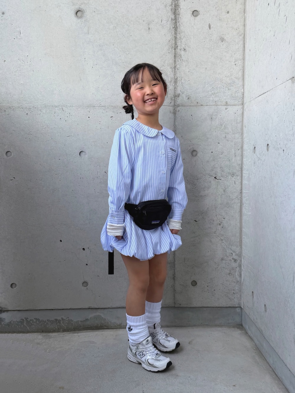 ブルー系のシャツ/ブラウス、ブラック系のボディバッグ/ウエストポーチ、ホワイト系のスニーカーを着用したキッズの春コーディネートの5枚目の写真