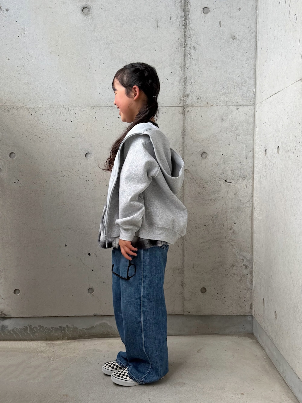 ブラック系のスカート、ブラック系のスリッポン、ホワイト系のトップスを着用したキッズの春コーディネートの2枚目の写真