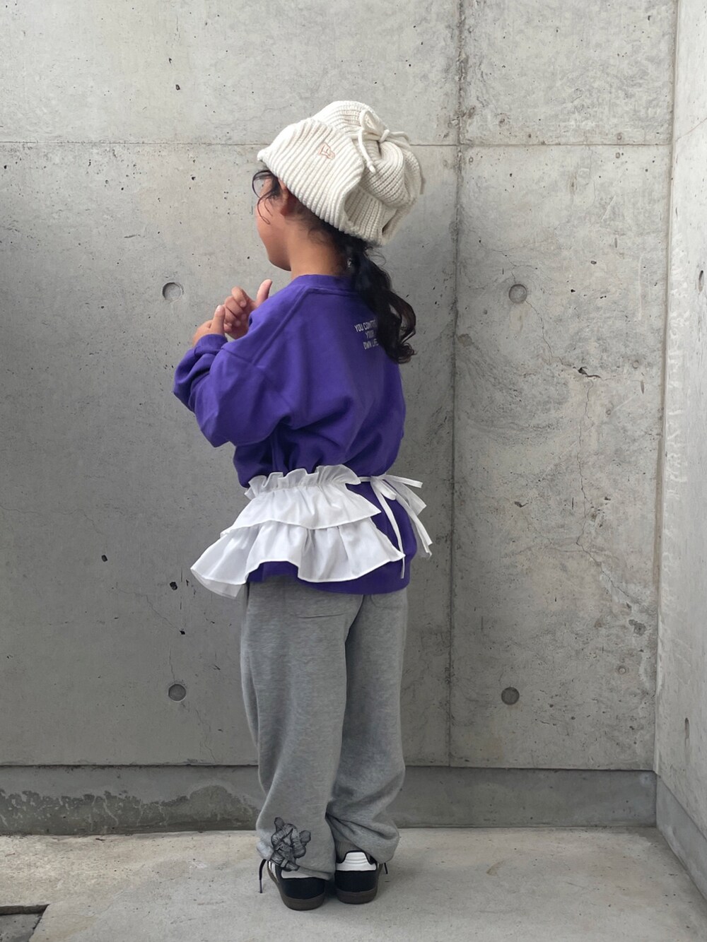 グレー系のパンツ、パープル系のTシャツ/カットソー、ブラック系のスニーカーを着用したキッズの秋コーディネートの3枚目の写真