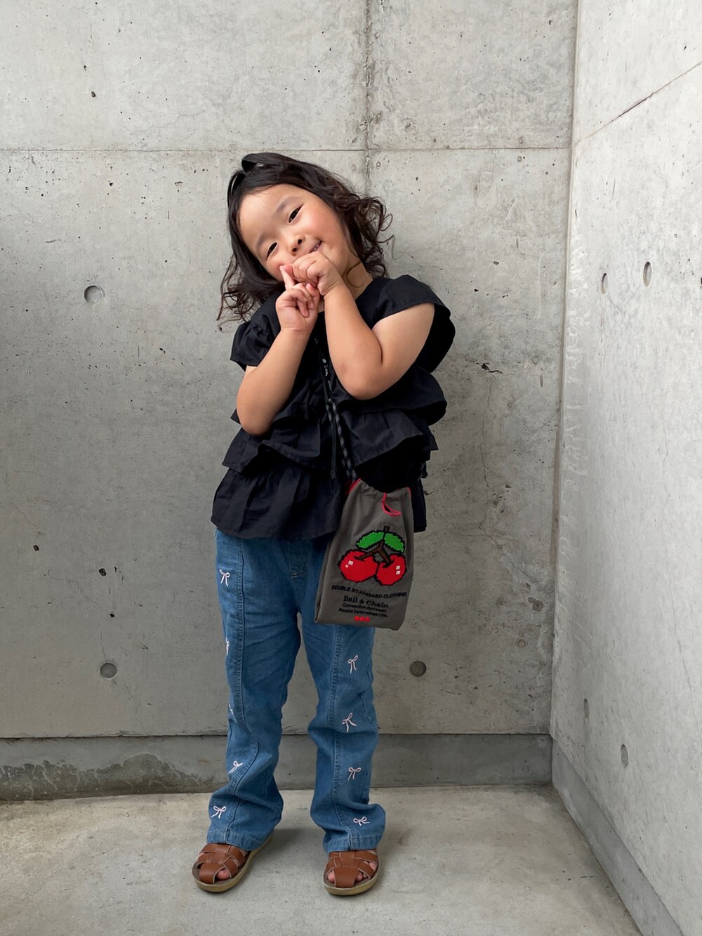 ブラック系のシャツ/ブラウス、グレー系のショルダーバッグ、ブルー系のパンツを着用したキッズの夏コーディネートの4枚目の写真