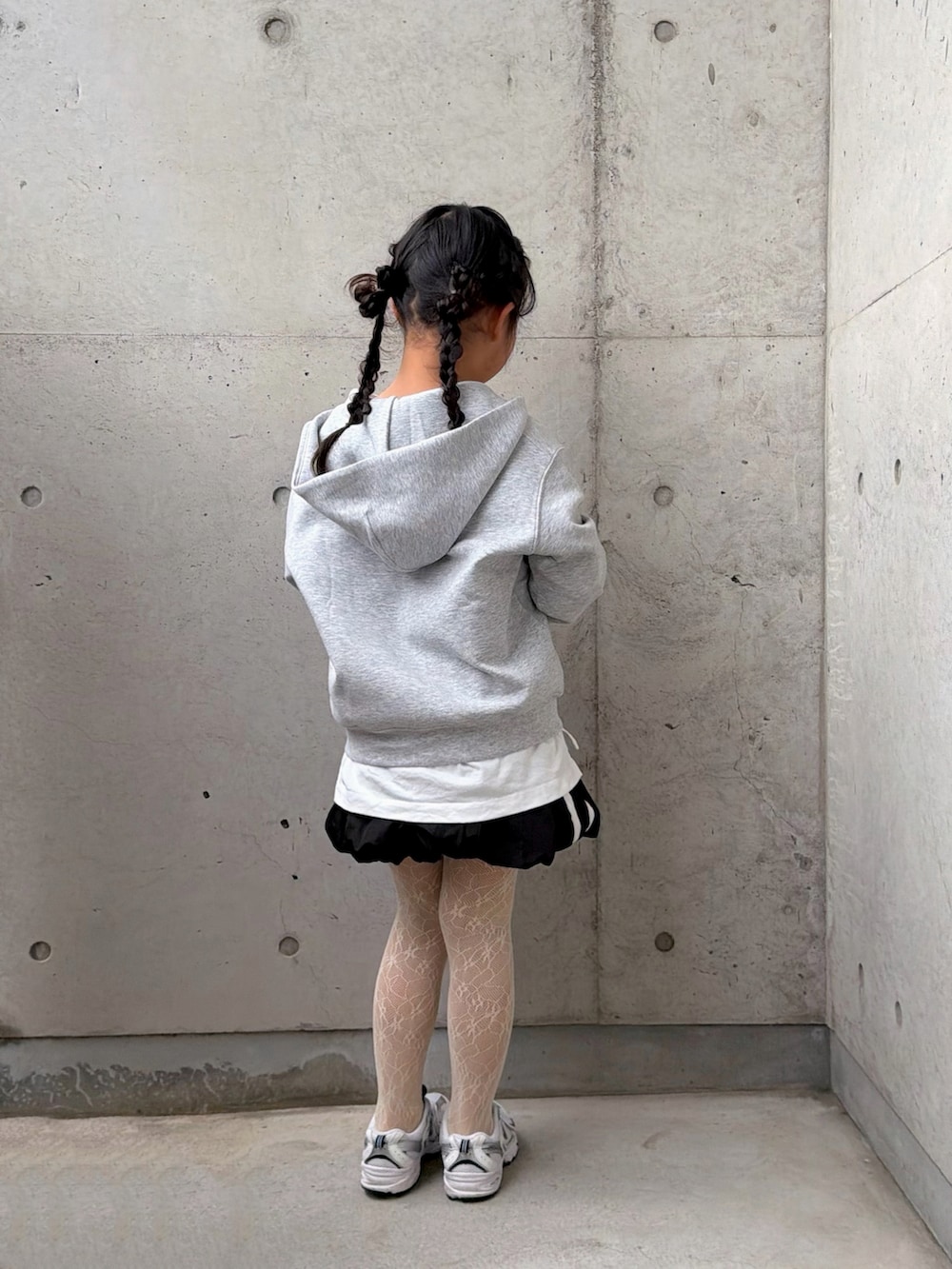 ホワイト系のTシャツ/カットソー、ブラック系のスカート、ホワイト系のスニーカーを着用したキッズの冬コーディネートの4枚目の写真