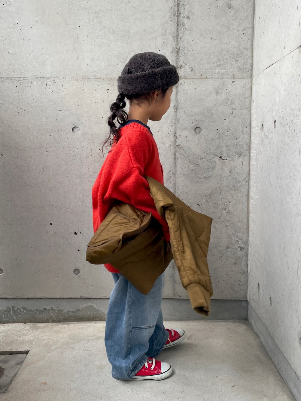 ブルー系のデニムパンツ、ブラウン系のダウンジャケット/コート、ブルー系のスウェットを着用したキッズの冬コーディネートの2枚目の写真