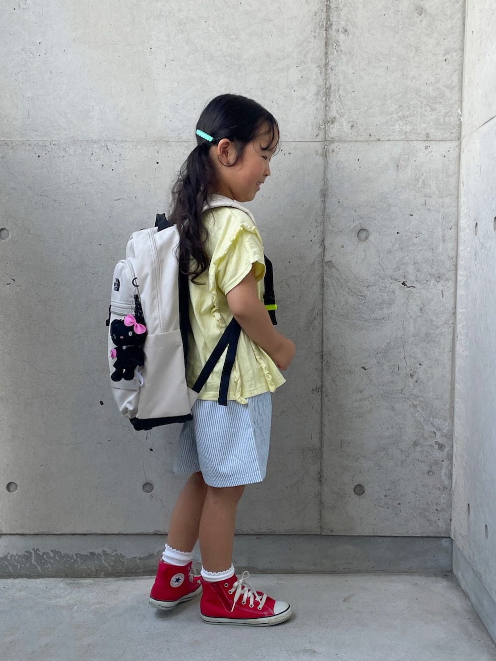 レッド系のスニーカー、ベージュ系のTシャツ/カットソー、ブルー系のパンツを着用したキッズの秋コーディネートの3枚目の写真