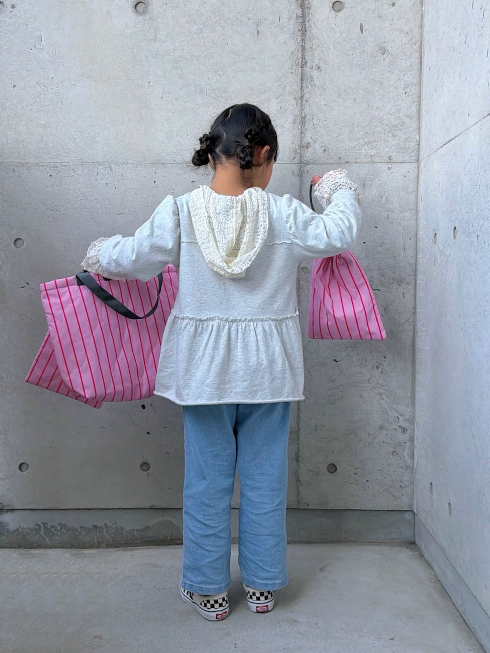 ホワイト系のTシャツ/カットソー、グレー系のワンピース、ピンク系のトートバッグを着用したキッズの冬コーディネートの3枚目の写真