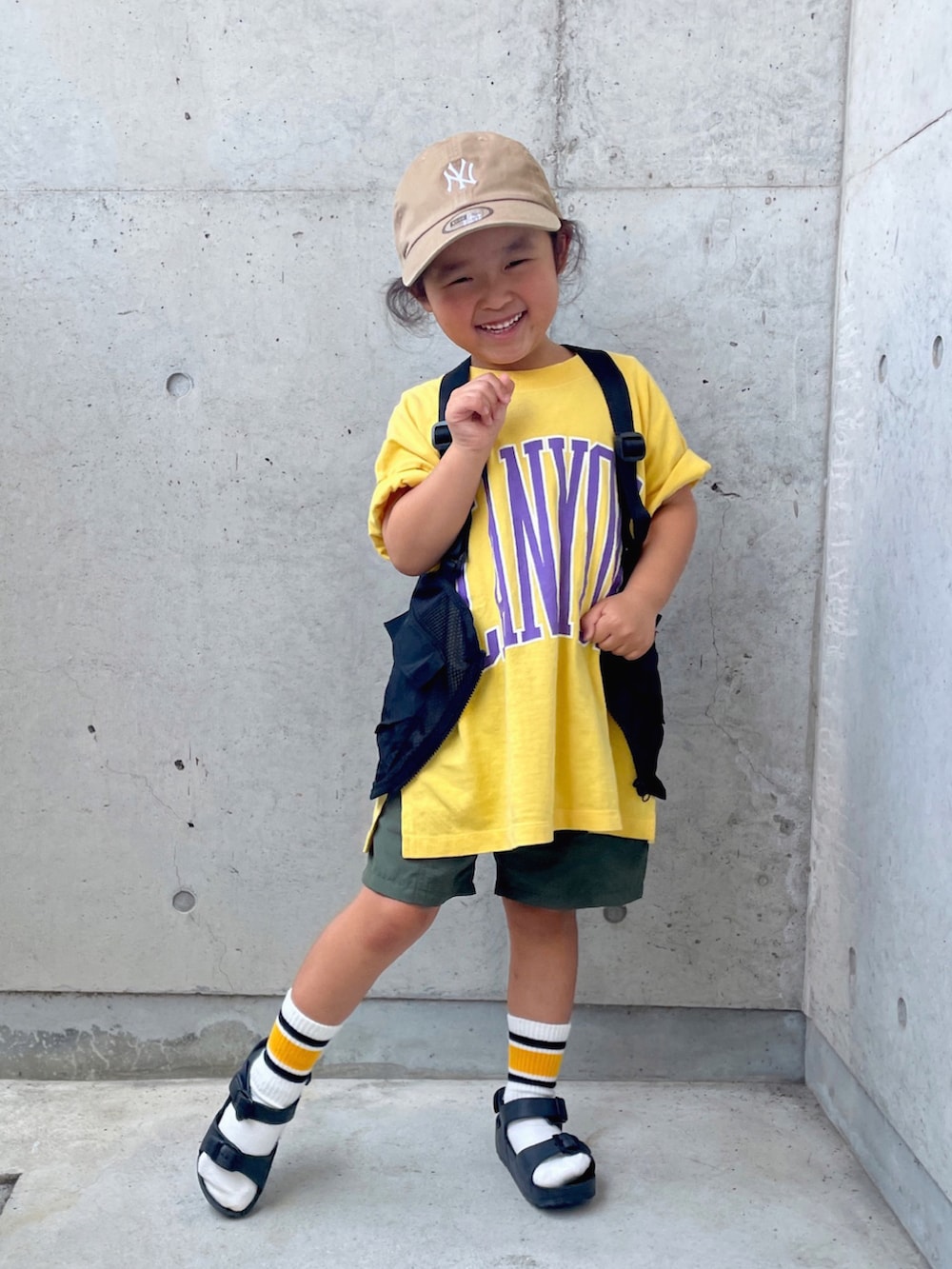 ブラック系のサンダル、ブラック系のベスト、グリーン系のパンツを着用したキッズの夏コーディネートの2枚目の写真