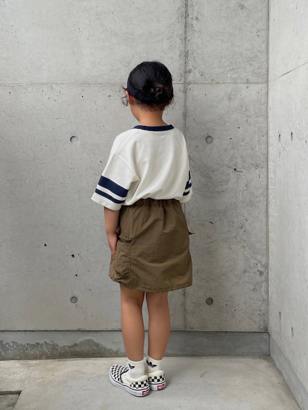 グリーン系のスカート、ブラック系のスリッポン、グリーン系のTシャツ/カットソーを着用したキッズの夏コーディネートの2枚目の写真