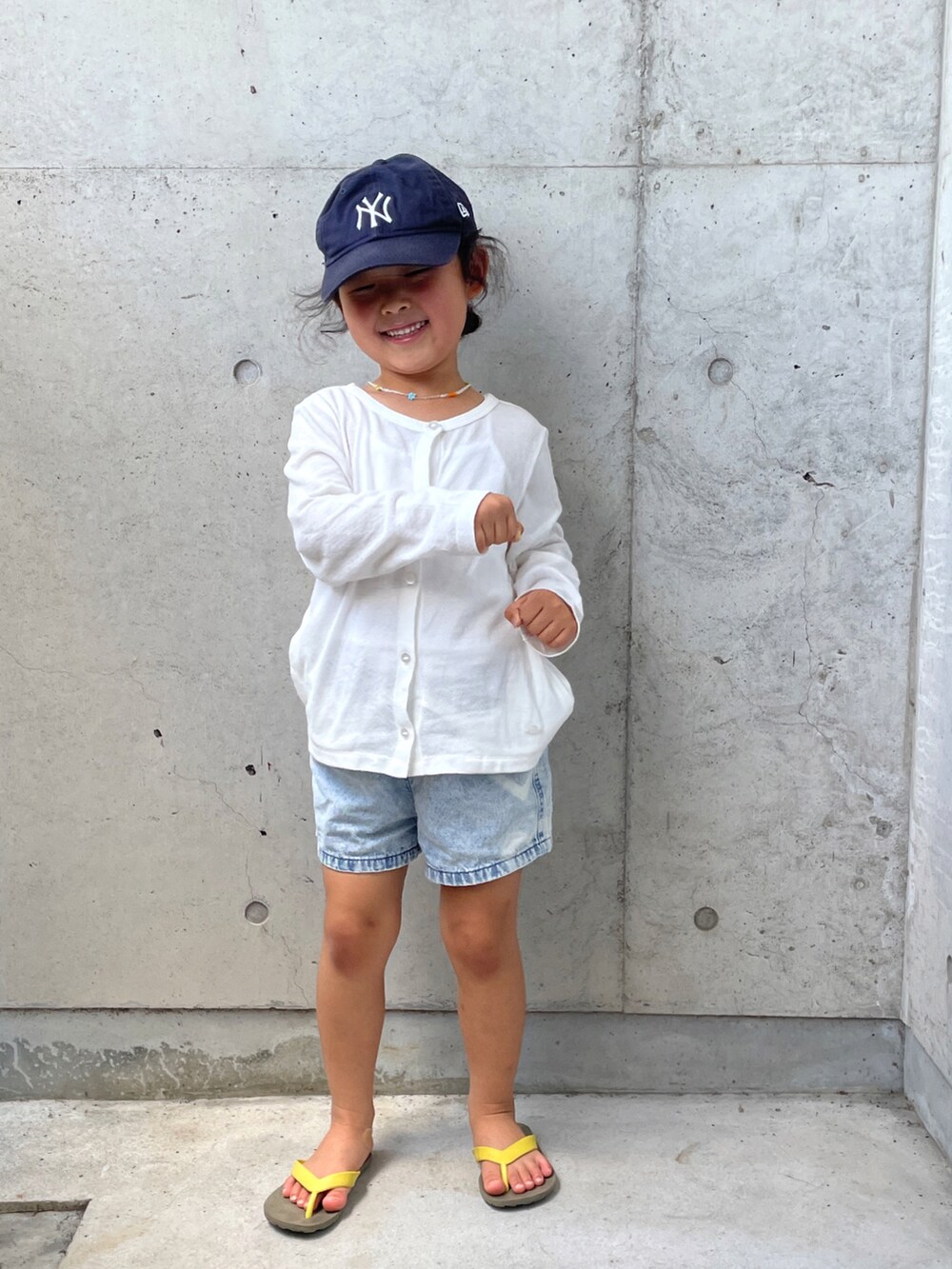 ブルー系のデニムパンツ、ブラウン系のサンダル、ホワイト系のTシャツ/カットソーを着用したキッズの夏コーディネートの2枚目の写真