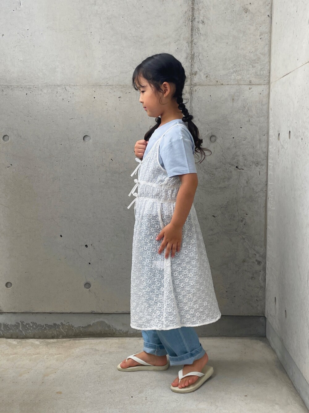 ブルー系のデニムパンツ、ホワイト系のサンダル、ホワイト系のワンピース/ドレスを着用したキッズの夏コーディネートの4枚目の写真
