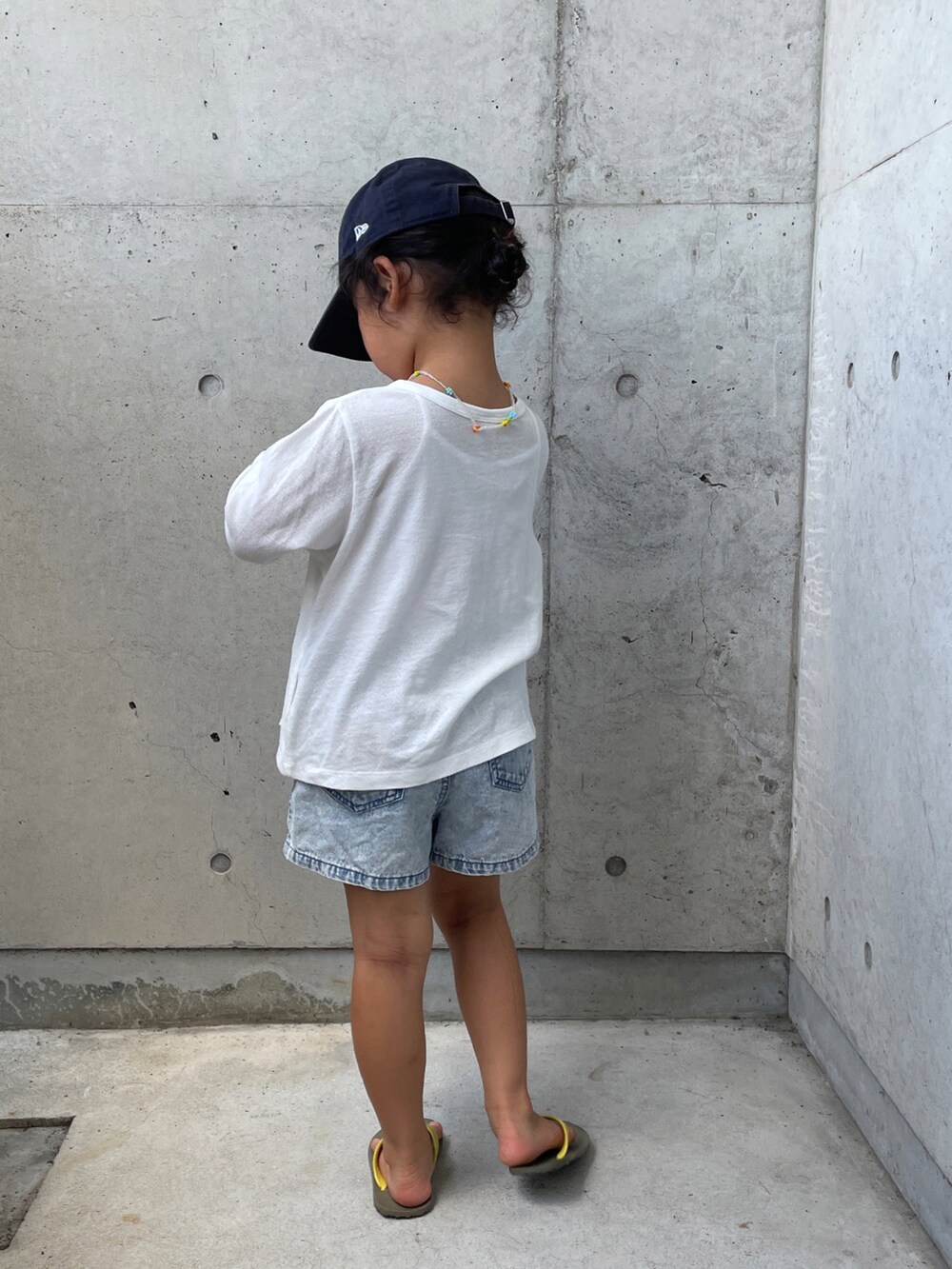 ブルー系のデニムパンツ、ブラウン系のサンダル、ホワイト系のTシャツ/カットソーを着用したキッズの夏コーディネートの3枚目の写真