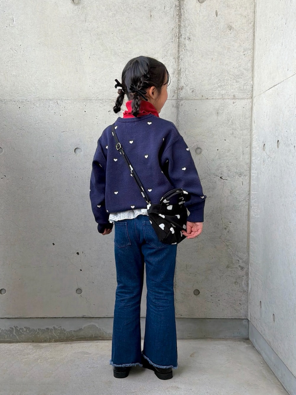 ブラック系のショルダーバッグ、ブルー系のニット/セーター、レッド系のニット/セーターを着用したキッズの冬コーディネートの3枚目の写真