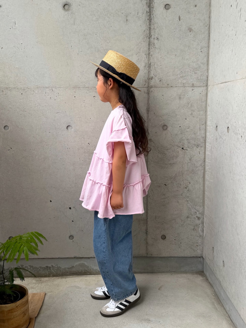 ピンク系のTシャツ/カットソー、ホワイト系のスニーカー、ブルー系のパンツを着用したキッズの春コーディネートの2枚目の写真