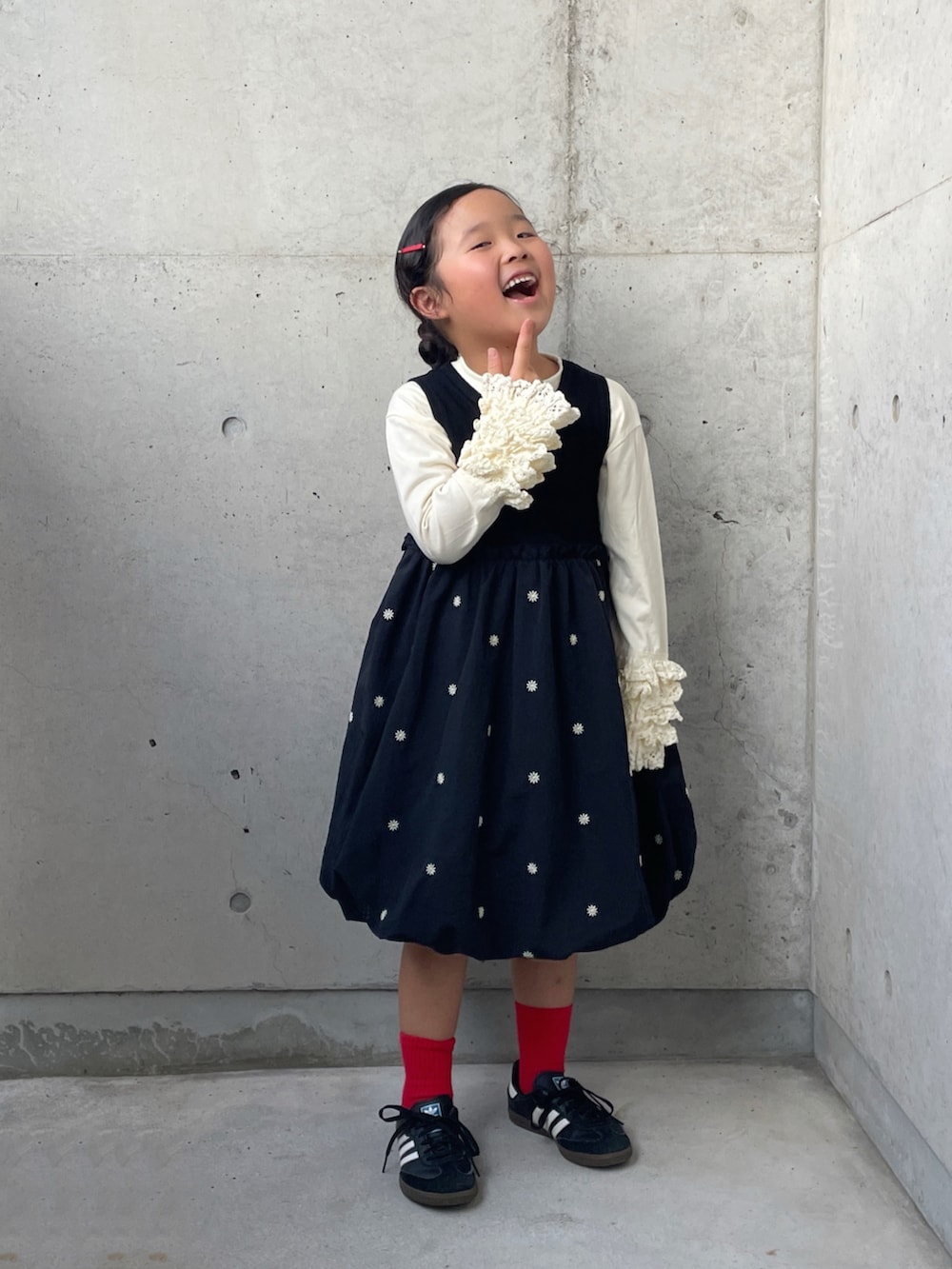 ブラック系のワンピース、ブラック系のスニーカー、ホワイト系のTシャツ/カットソーを着用したキッズの秋コーディネートの2枚目の写真