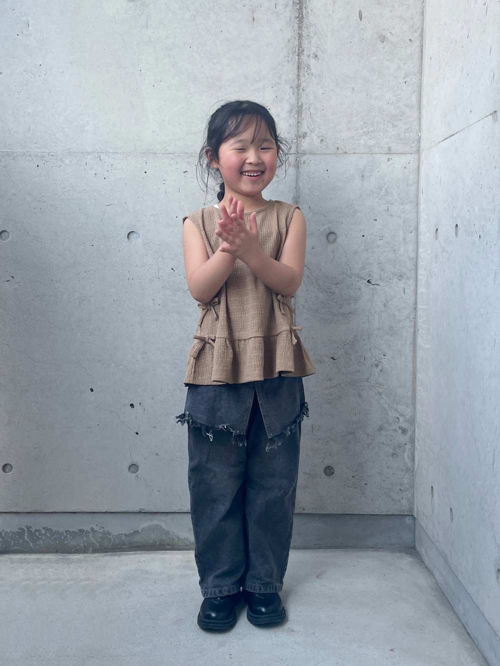 ブラウン系のパンツドレス、ブラック系のブーツ、ブラック系のパンツを着用したキッズの夏コーディネートの4枚目の写真