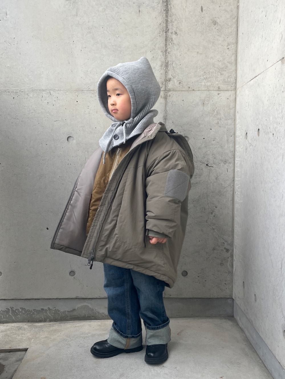 レッド系のスウェット、グリーン系のブルゾン、ブラウン系のダウンジャケット/コートを着用したキッズの冬コーディネートの3枚目の写真