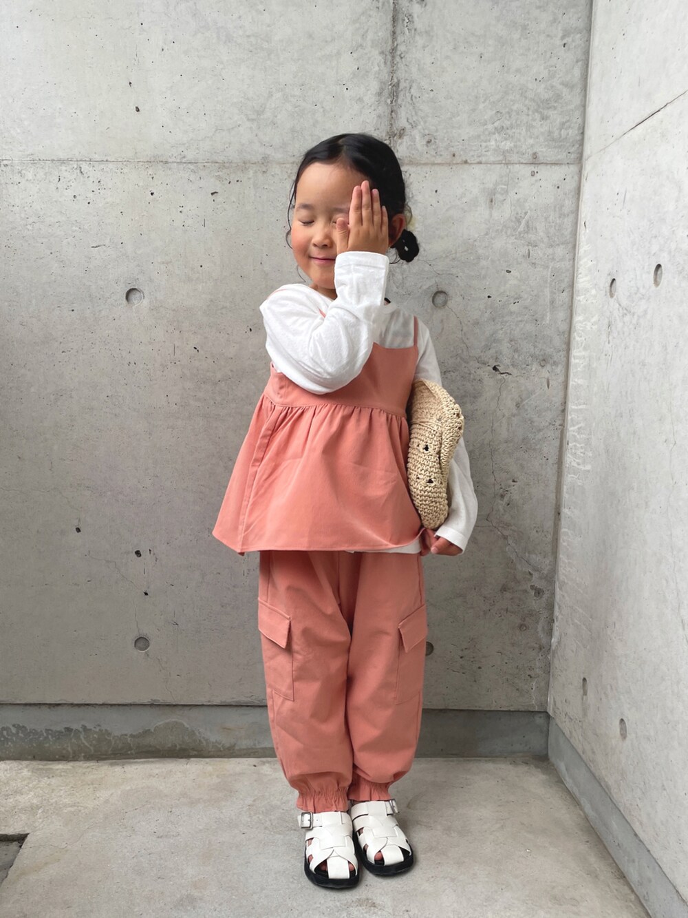 オレンジ系のTシャツ/カットソー、オレンジ系のその他パンツ、ホワイト系のサンダルを着用したキッズの春コーディネートの2枚目の写真