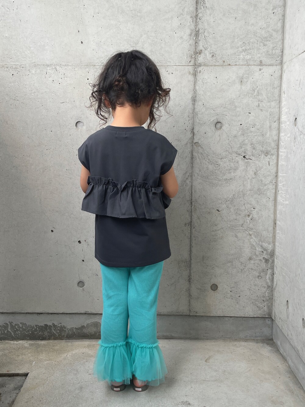 グレー系のタンクトップ、ホワイト系のサンダル、ブルー系のパンツを着用したキッズの夏コーディネートの5枚目の写真