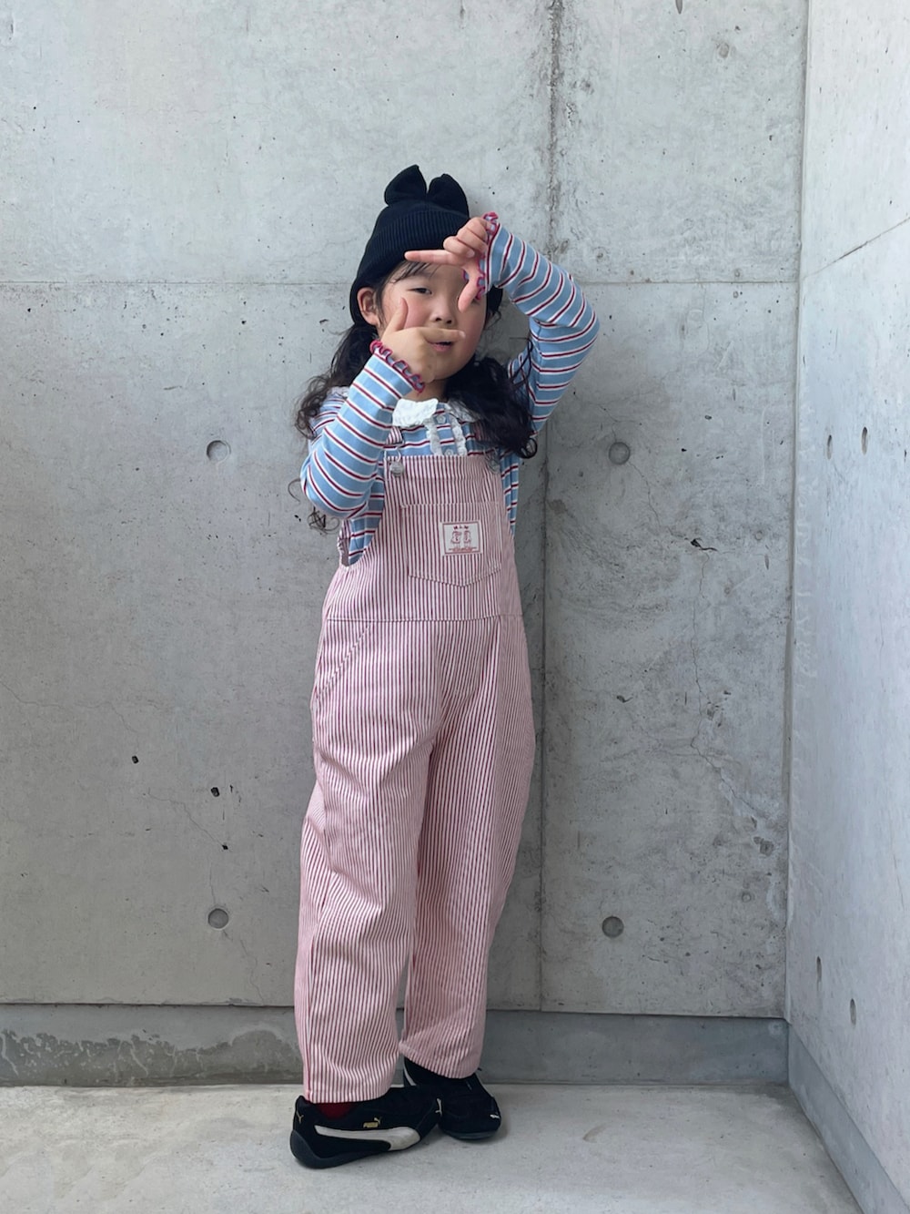 ブラック系のスニーカー、ブルー系のトップス、レッド系のオールインワン・サロペットを着用したキッズの夏コーディネートの4枚目の写真