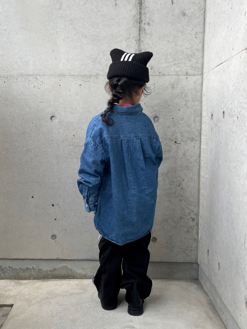 ブラック系のパンツ、ピンク系のニット/セーター、ブルー系のシャツ/ブラウスを着用したキッズの冬コーディネートの3枚目の写真