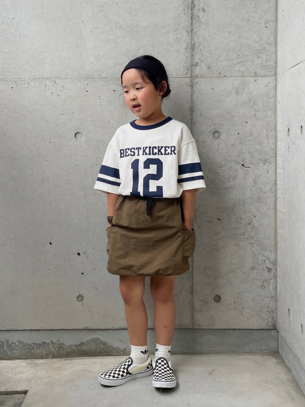 グリーン系のスカート、ブラック系のスリッポン、グリーン系のTシャツ/カットソーを着用したキッズの夏コーディネートの4枚目の写真