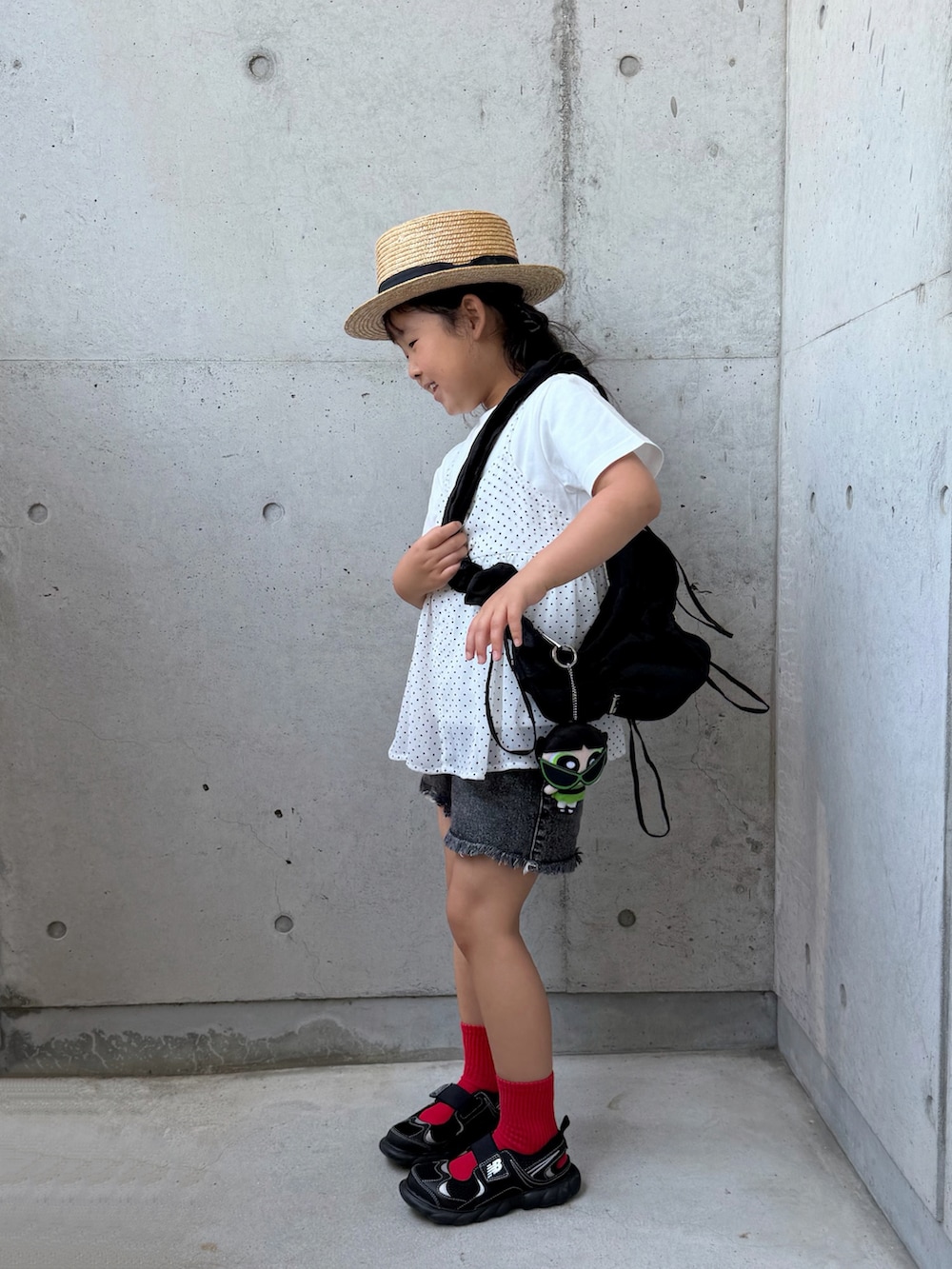 ブラック系のデニムパンツ、ホワイト系のTシャツ/カットソー、ブラック系のサンダルを着用したキッズの夏コーディネートの3枚目の写真