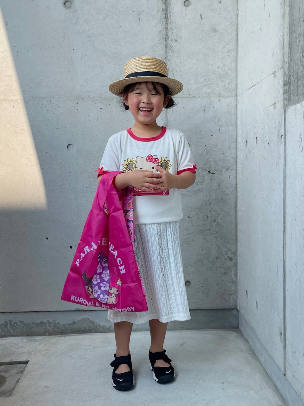 ホワイト系のワンピース、ブラック系のその他パンツ、ブラック系のスニーカーを着用したキッズの夏コーディネートの2枚目の写真