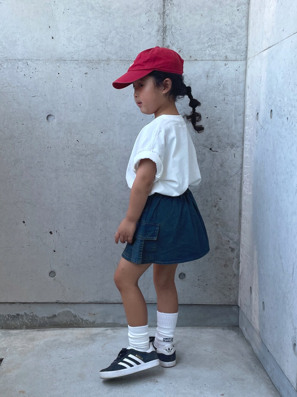 ブルー系のスカート、ブラック系のスニーカー、ホワイト系のTシャツ/カットソーを着用したキッズの夏コーディネートの2枚目の写真