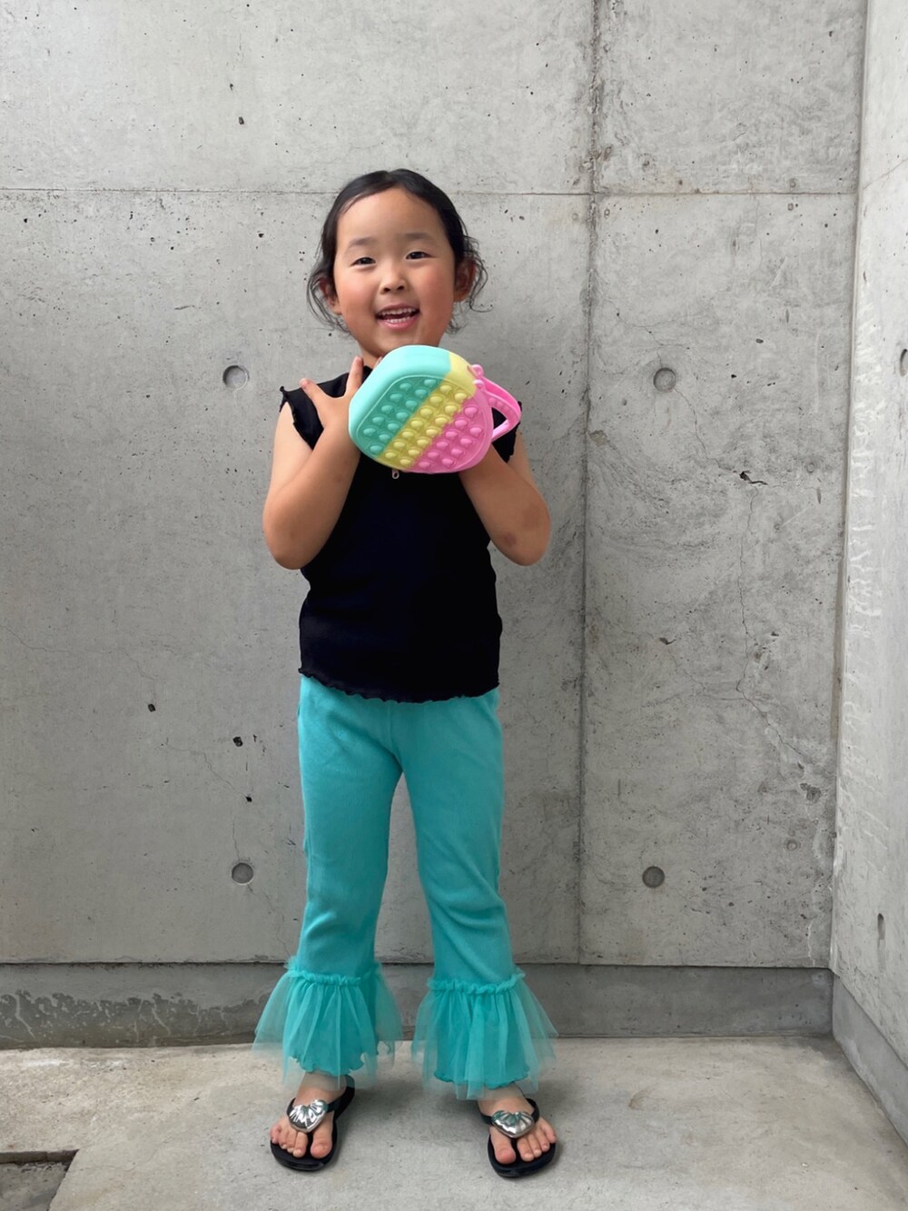 ブラック系のサンダル、ブラック系のトップス、ブルー系のパンツを着用したキッズの春コーディネートの3枚目の写真