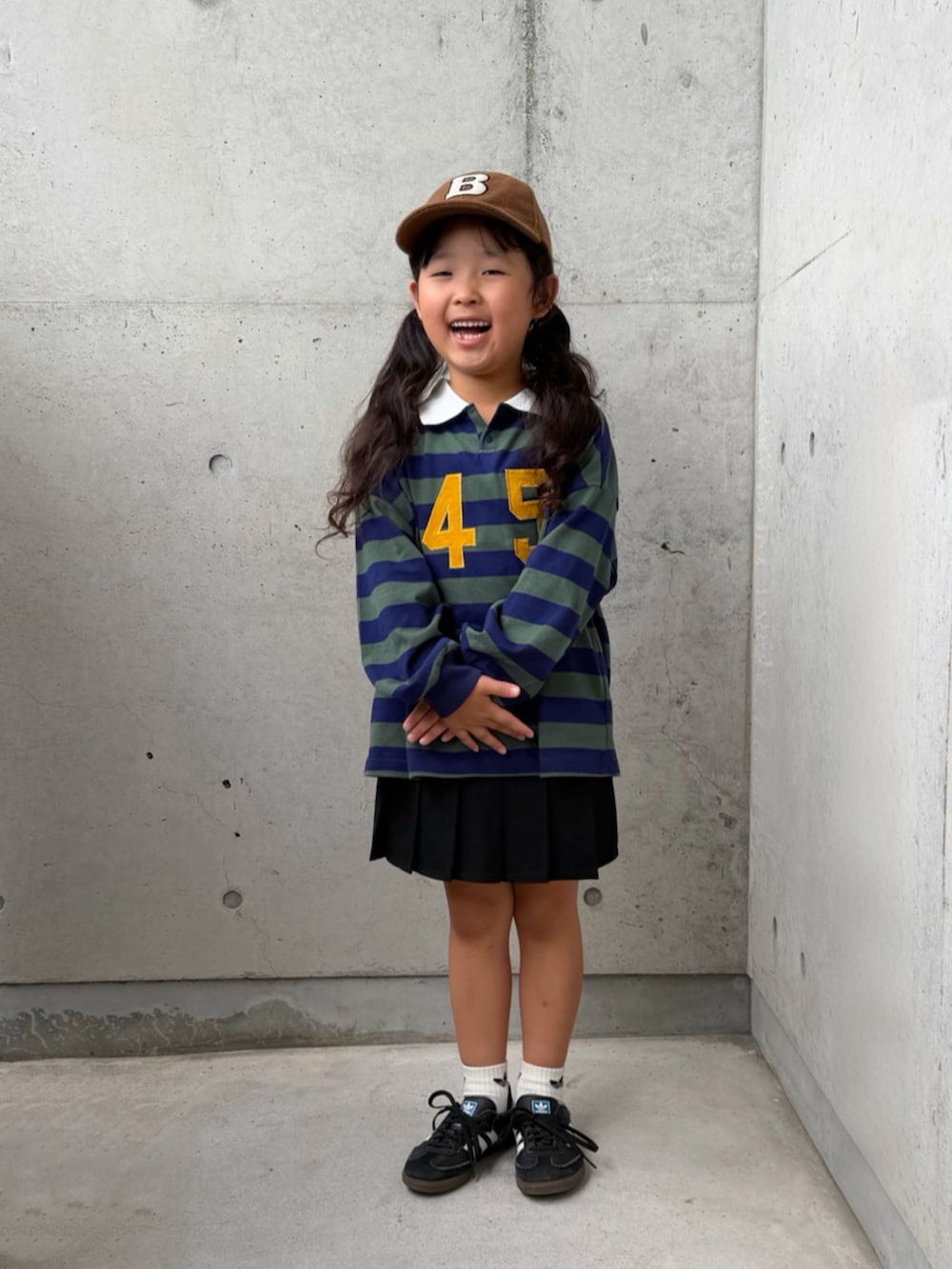 ブラック系のスニーカー、グリーン系のポロシャツ、イエロー系のバックパック/リュックを着用したキッズの秋コーディネートの3枚目の写真