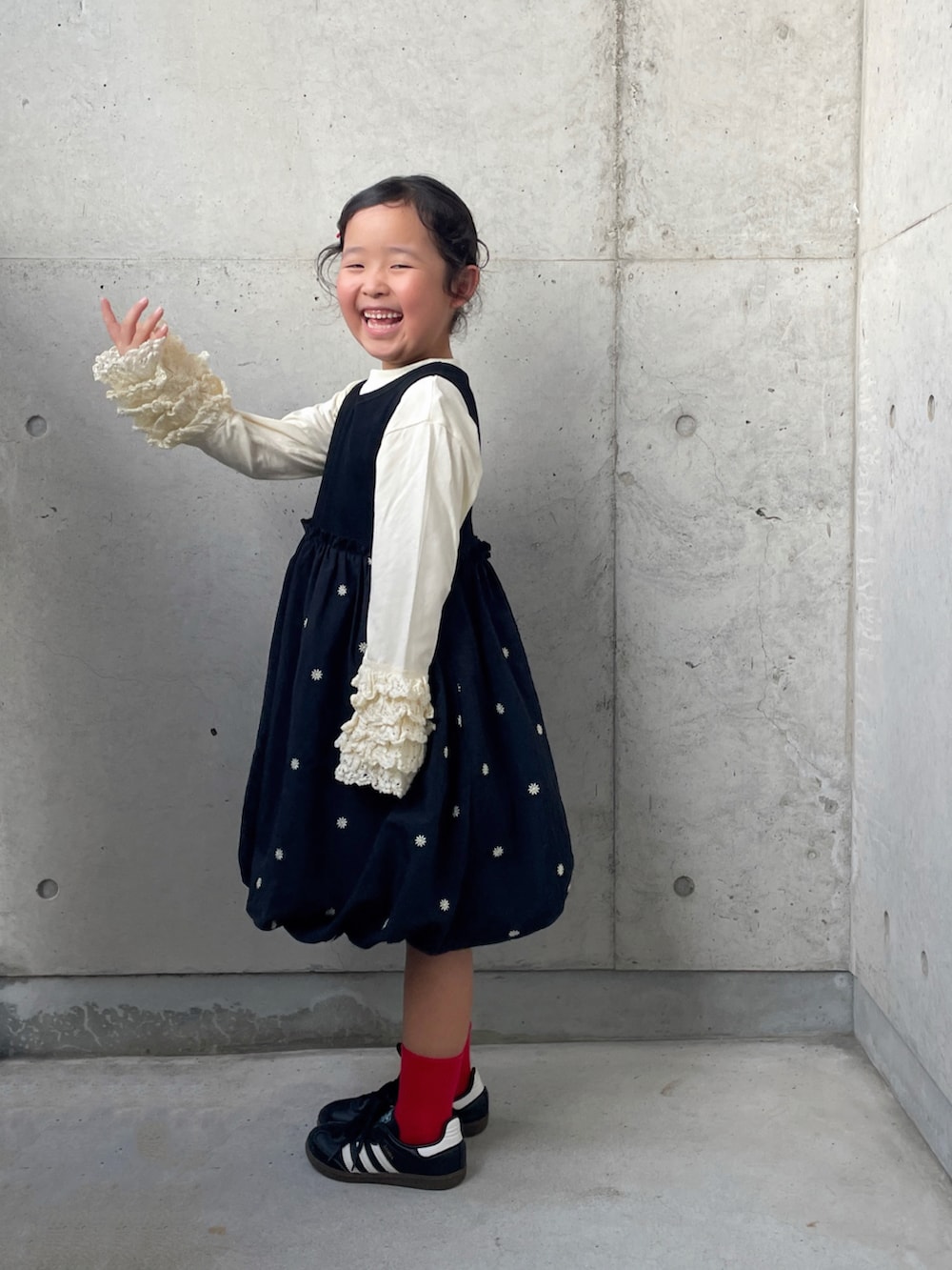 ブラック系のワンピース、ブラック系のスニーカー、ホワイト系のTシャツ/カットソーを着用したキッズの秋コーディネートの4枚目の写真