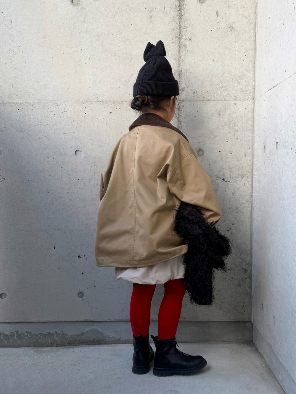 ベージュ系のスウェット、ベージュ系のスカート、ブラック系のトートバッグを着用したキッズの秋コーディネートの3枚目の写真