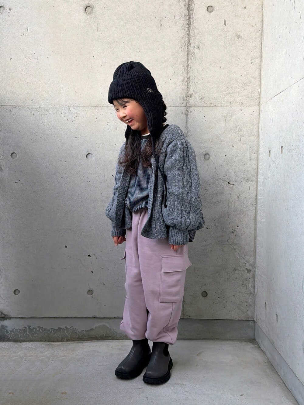 ピンク系のカーゴパンツ、グレー系のブーツ、ブラック系のTシャツ/カットソーを着用したキッズの冬コーディネートの2枚目の写真