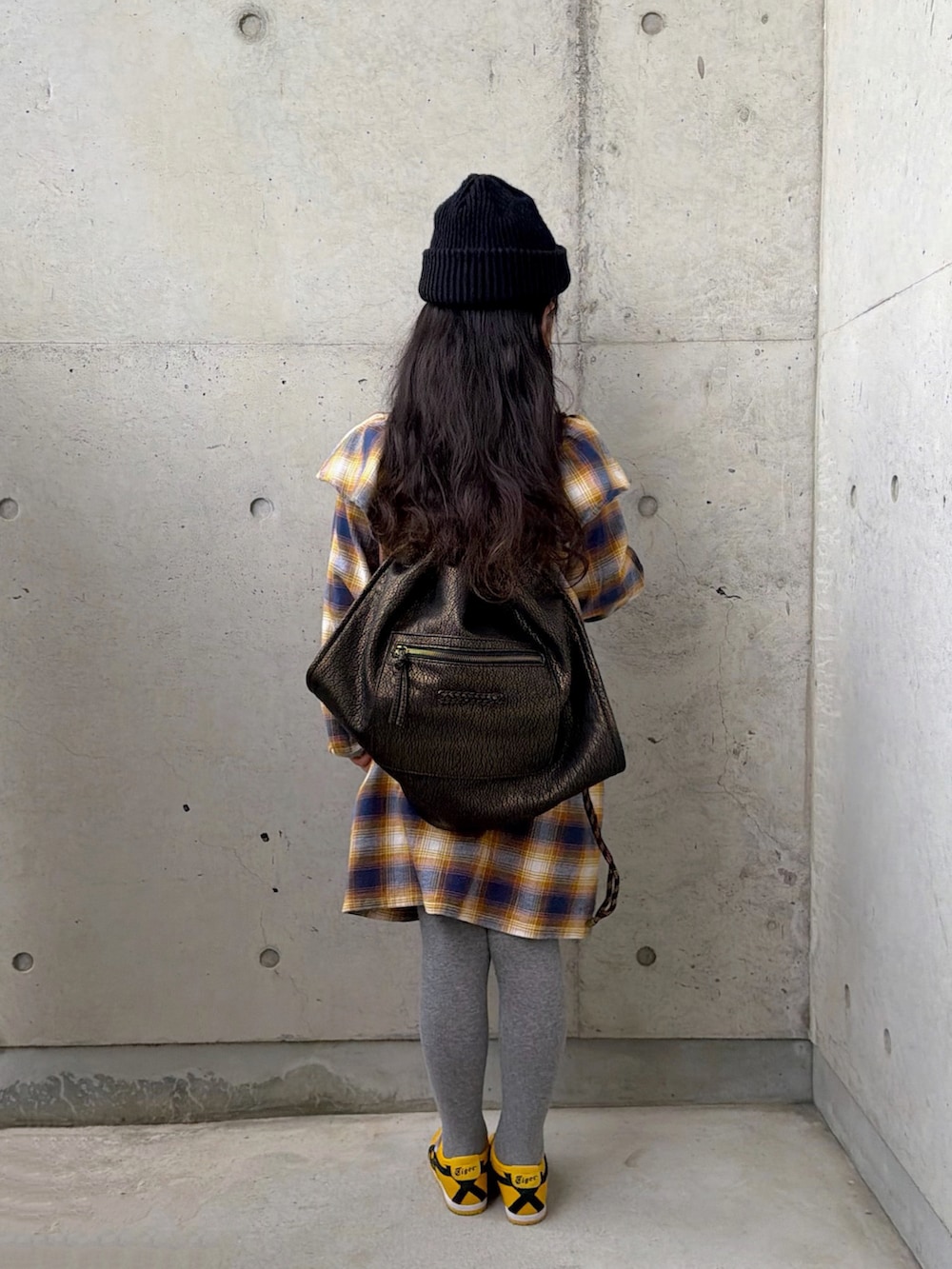 イエロー系のワンピース、イエロー系のスニーカー、ブラック系のバックパック/リュックを着用したキッズの春コーディネートの3枚目の写真