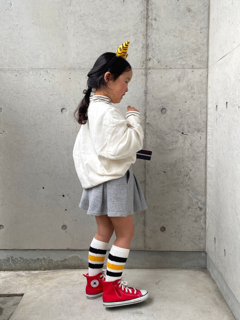 レッド系のスニーカー、ホワイト系のTシャツ/カットソー、ホワイト系のスウェットを着用したキッズの冬コーディネートの5枚目の写真