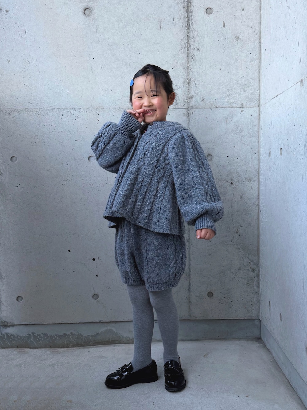 グレー系のニット/セーター、グレー系のその他パンツ、その他のローファーを着用したキッズの冬コーディネートの4枚目の写真