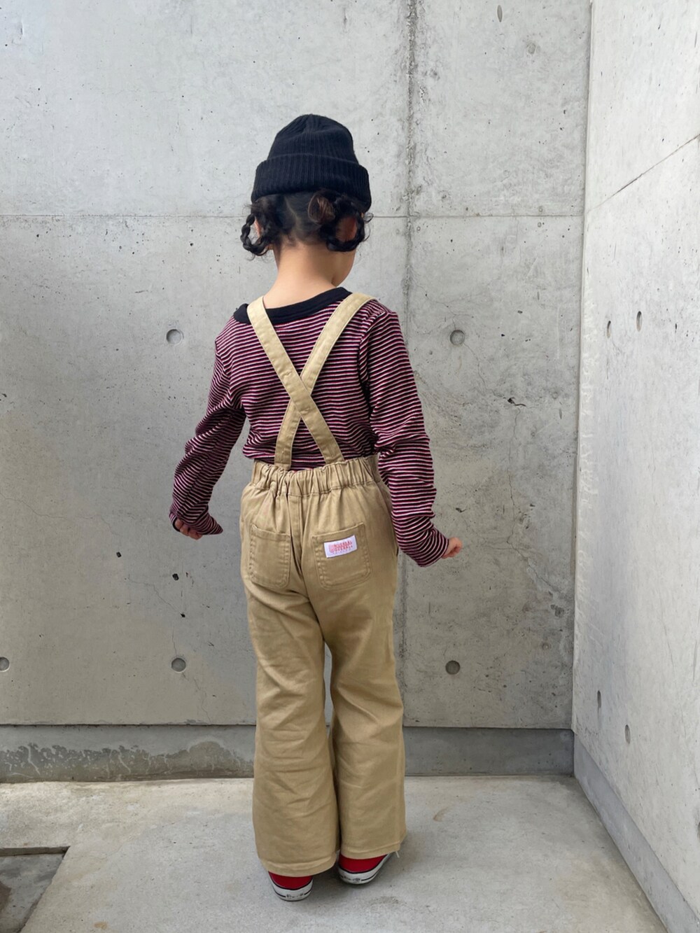 レッド系のスニーカー、レッド系のTシャツ/カットソー、ベージュ系のサロペット/オーバーオールを着用したキッズの春コーディネートの5枚目の写真