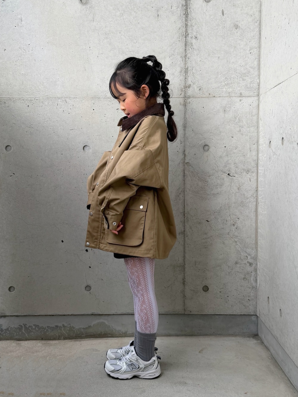 パープル系のポロシャツ、ベージュ系のミリタリージャケット、ブラック系のその他パンツを着用したキッズの冬コーディネートの2枚目の写真