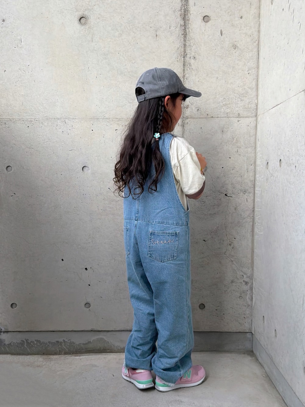 ブルー系のサロペット/オーバーオール、ピンク系のスニーカー、ホワイト系のTシャツ/カットソーを着用したキッズの春コーディネートの3枚目の写真