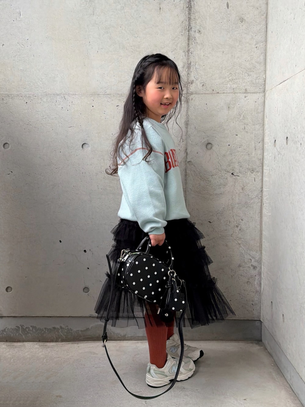 その他のボストンバッグ、グリーン系のニット/セーター、ブラック系のスカートを着用したキッズの冬コーディネートの2枚目の写真